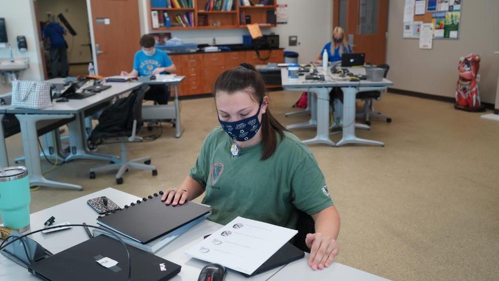 Student with face mask working at desk